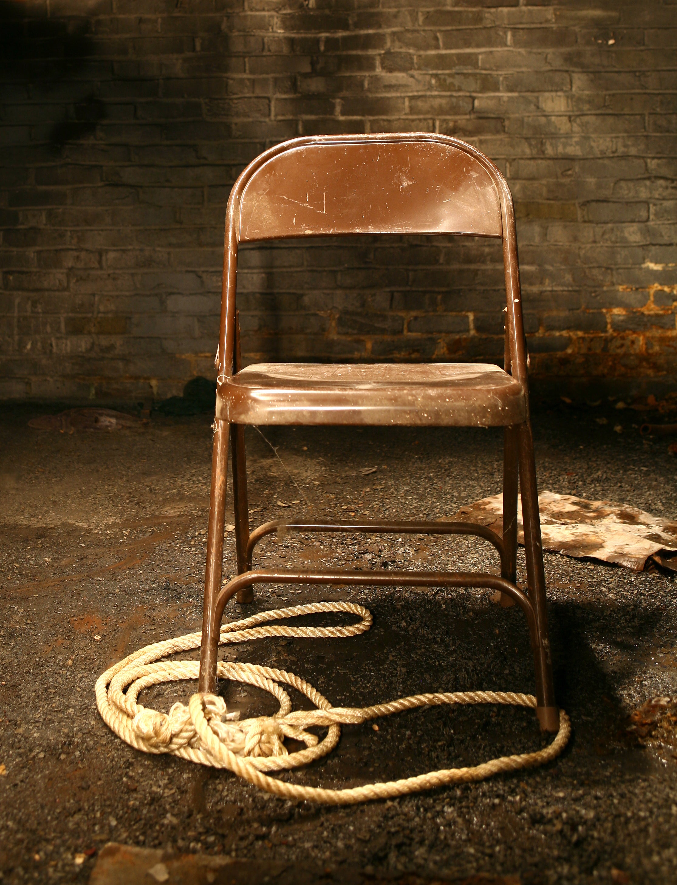 A chair with rope on the ground near it