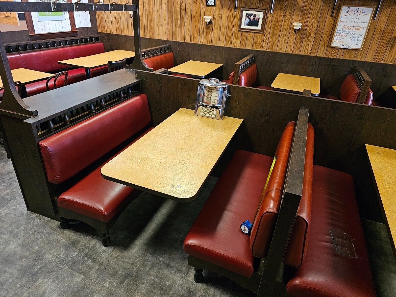 An empty diner with booths, a jukebox, and vintage decor