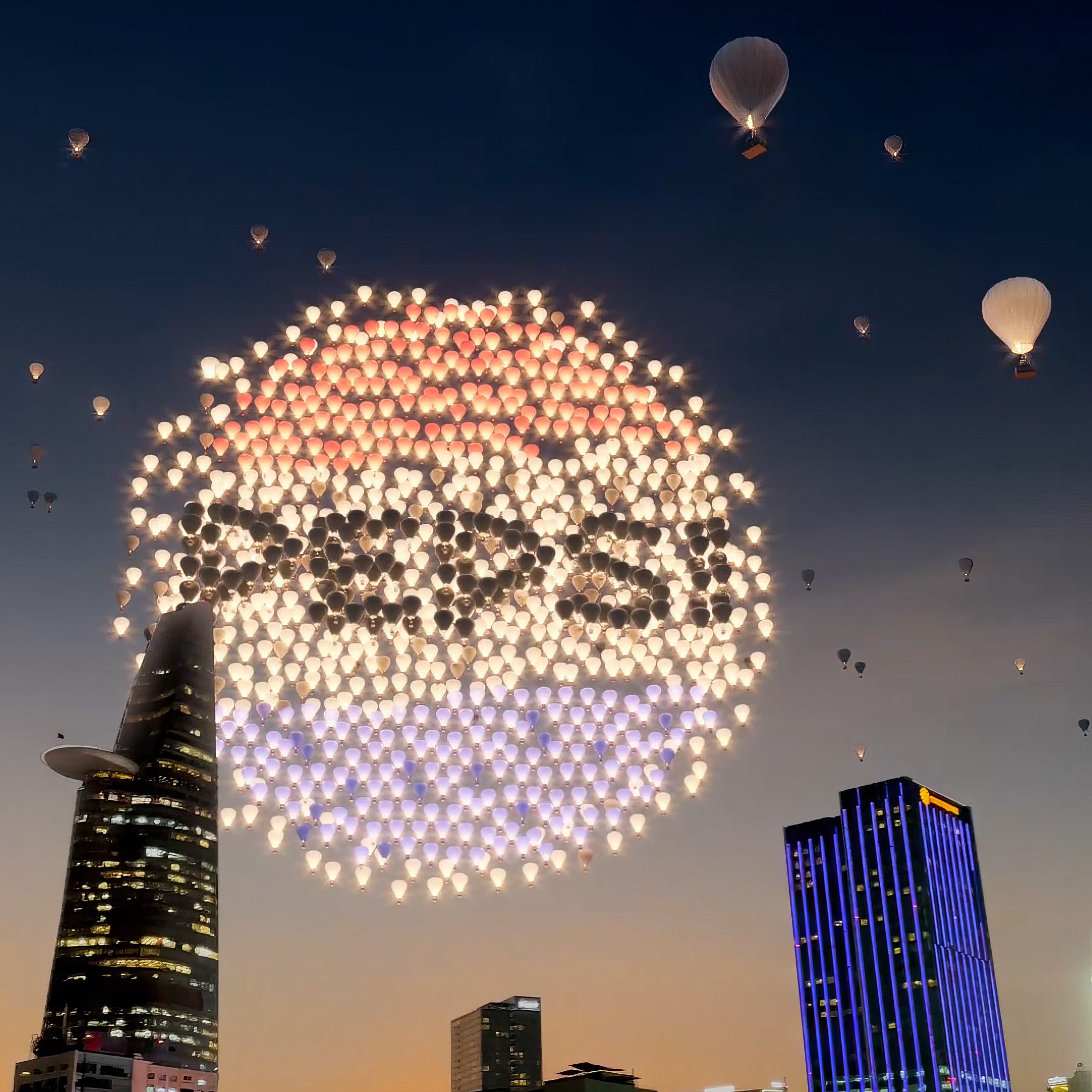 Hot air balloons create a large pattern in the sky above city skyline at dusk
