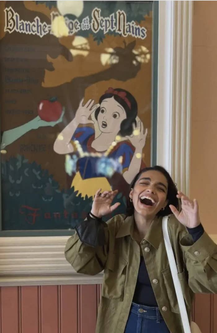 Rachel Zegler looking scared in front of a Snow White poster