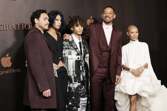 Will, Jada, and their children posing at a media event