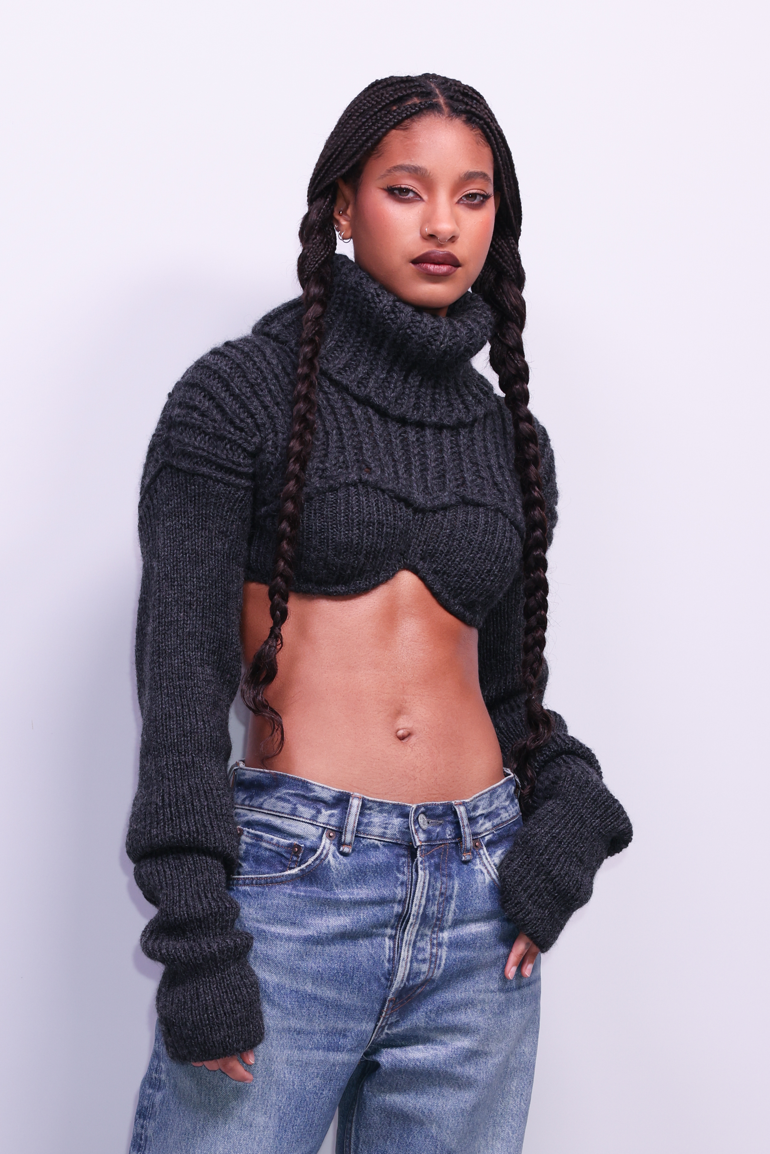 WIllow poses in a cropped turtleneck sweater and jeans