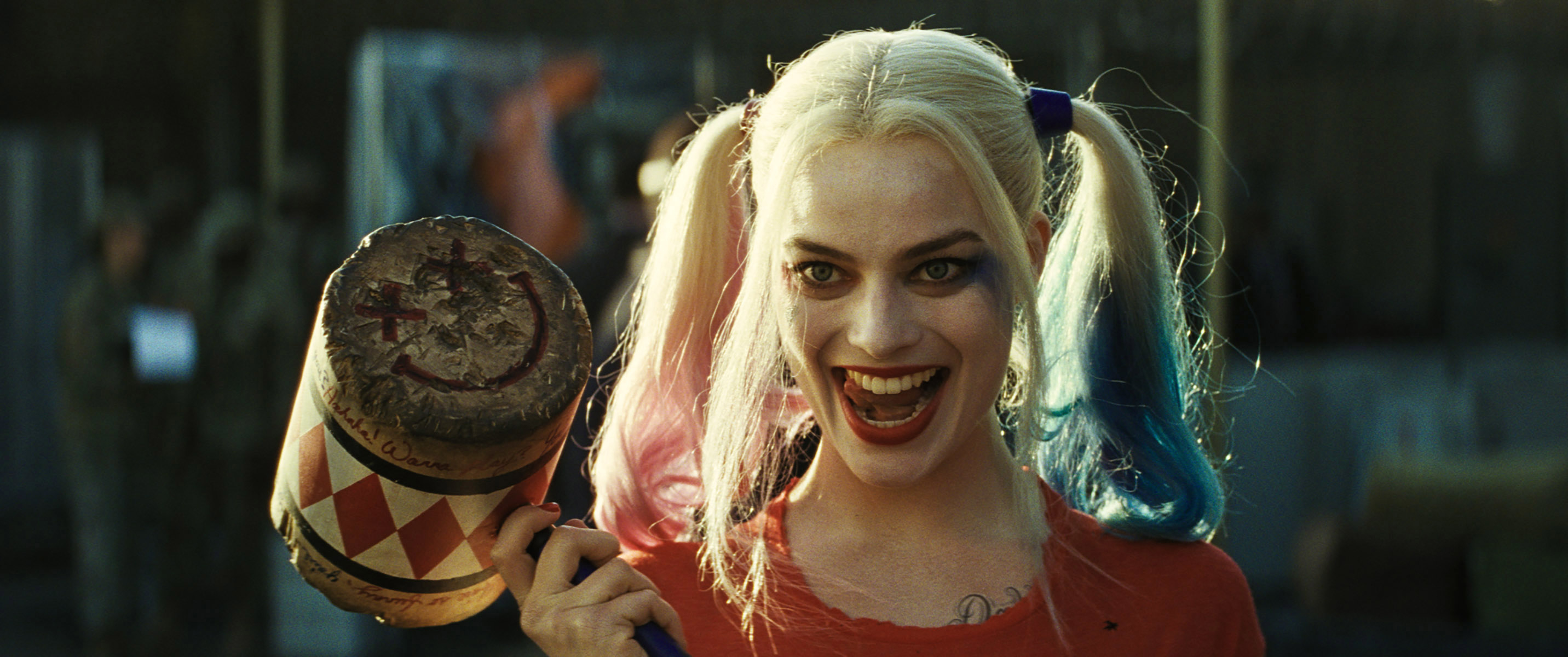 Harley Quinn holds a mallet, wearing pigtails and a mischievous smile