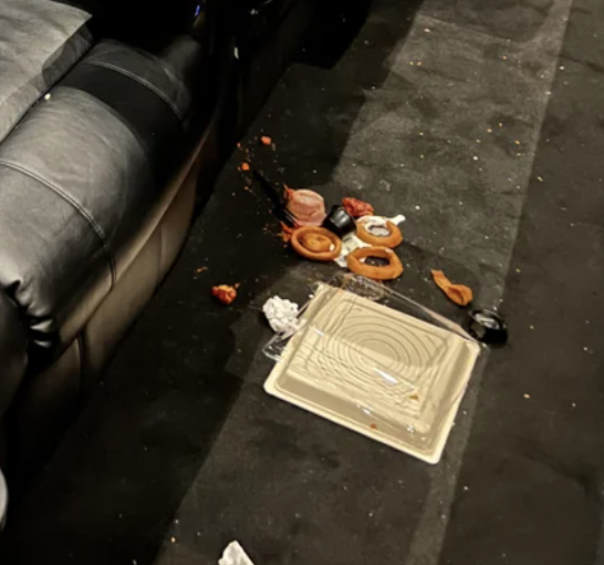 Spilled onion rings and a broken plate on the floor near theater chairs