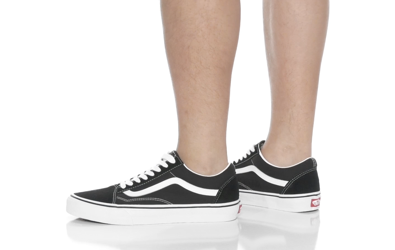Person wearing classic black and white canvas sneakers