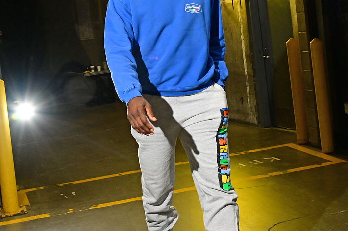 LeBron James wearing casual sweatpants and a hoodie paired with blue and green sneakers