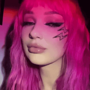 Mujer con peluca rosa y maquillaje de ojo con rayo de purpurina