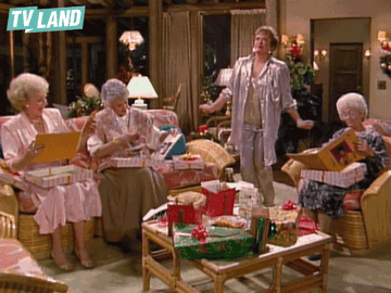 Four characters from &quot;The Golden Girls&quot; are sitting in a living room exchanging gifts