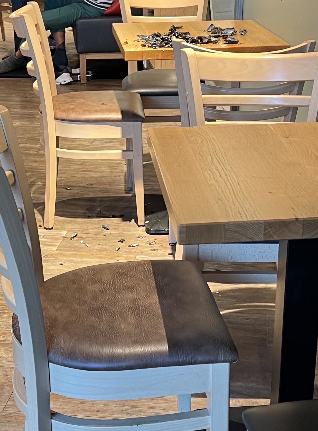 Empty diner chairs and scattered mussel shells on the floor and on the table