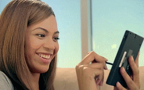 Beyoncé smiling at a phone screen and interacting with content