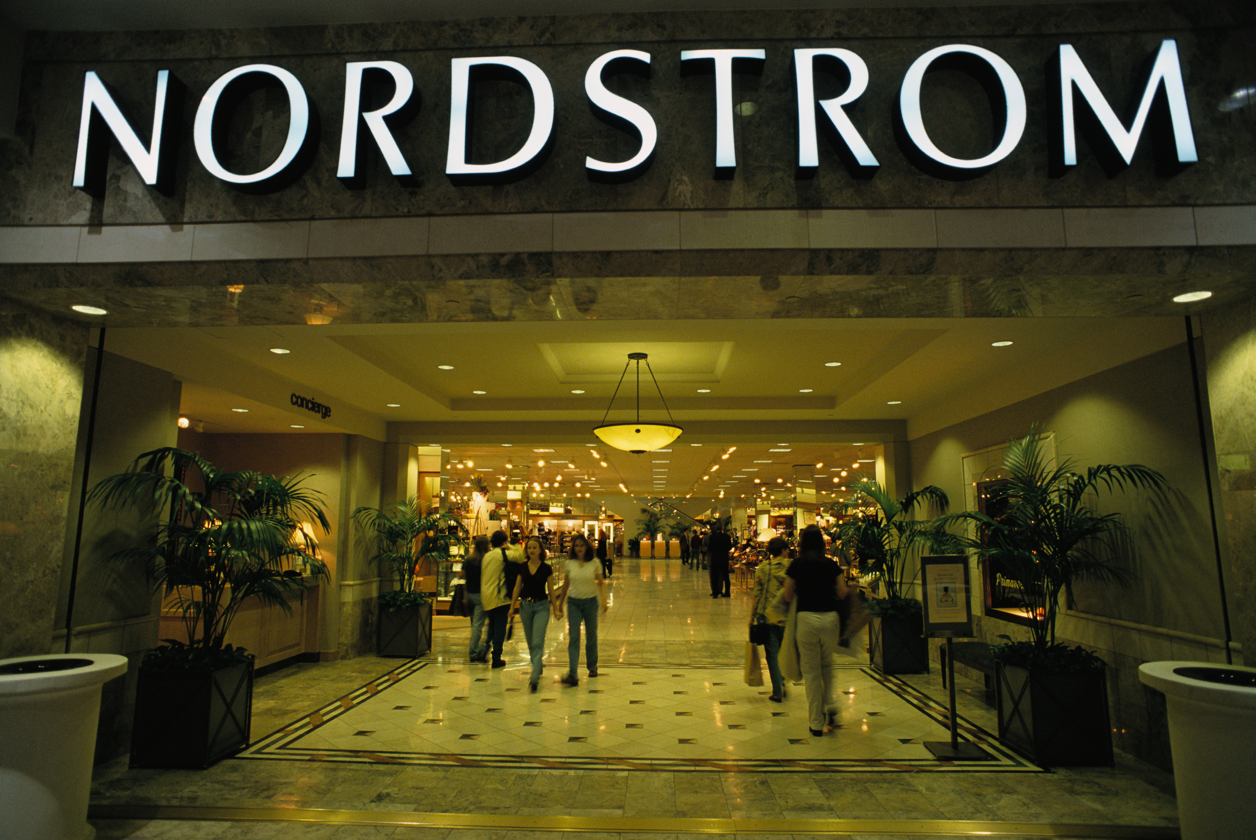Entrance to Nordstrom store with shoppers walking in and out