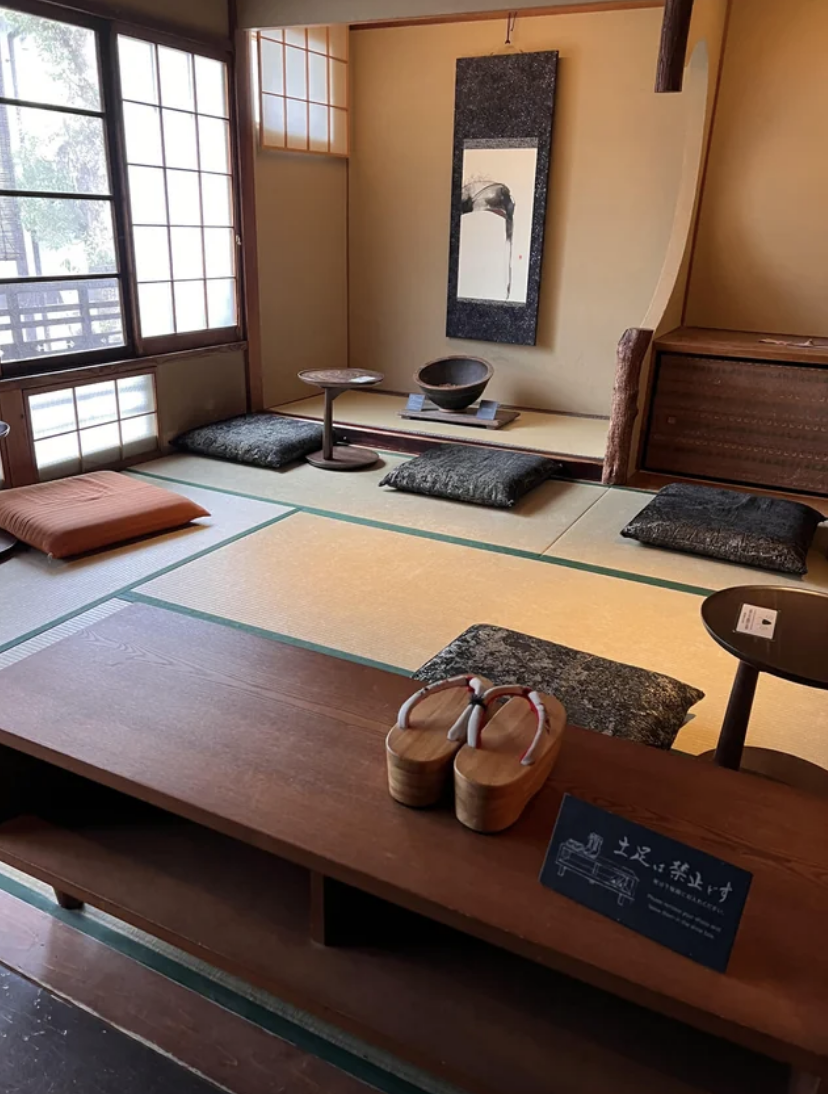 Traditional Japanese tatami room setup with low table, floor cushions, and tea set