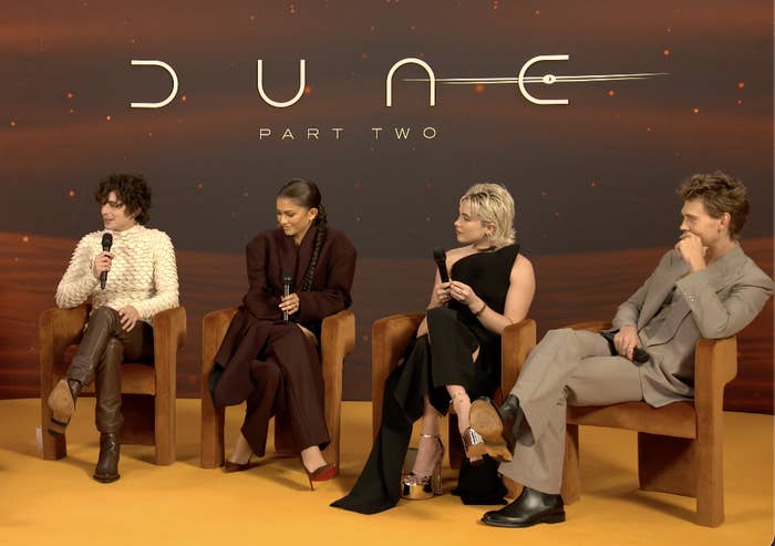 Four cast members seated during a &#x27;Dune: Part Two&#x27; press event, engaged in conversation, dressed in stylish attire