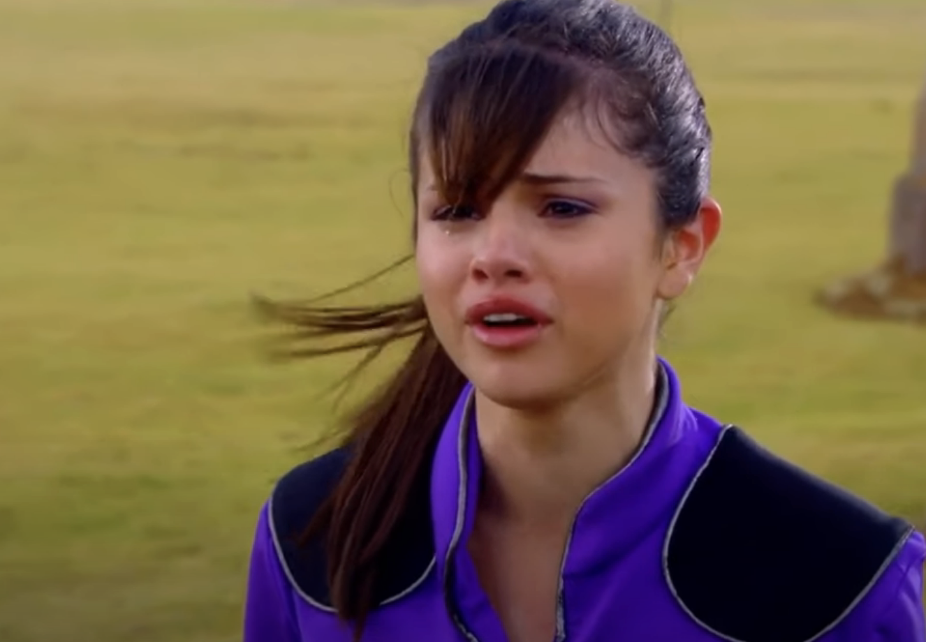 Selena Gomez looks concerned in a purple jacket outdoors