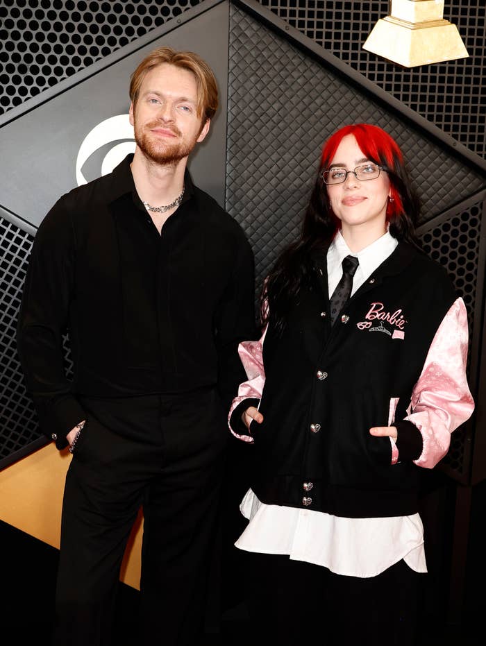 The duo posing together on the red carpet. Billie is wearing a satin jacket with &quot;Billie Eilish&quot; embroidered on it