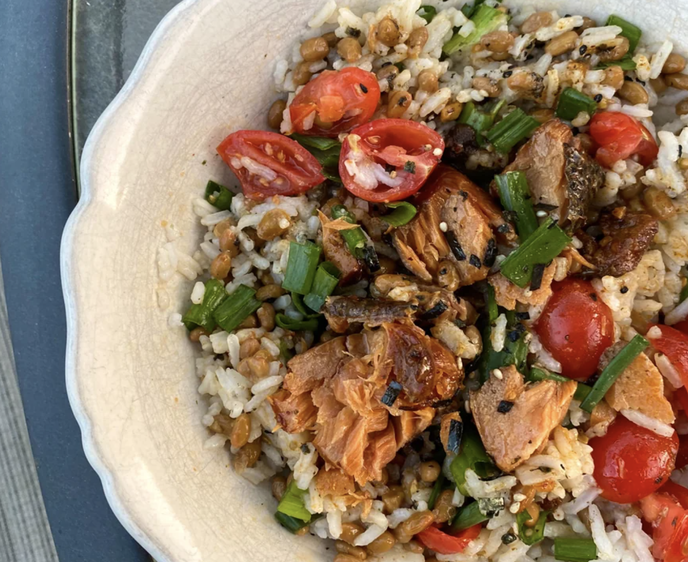 Bowl of rice with vegetables, chicken, and sliced tomatoes