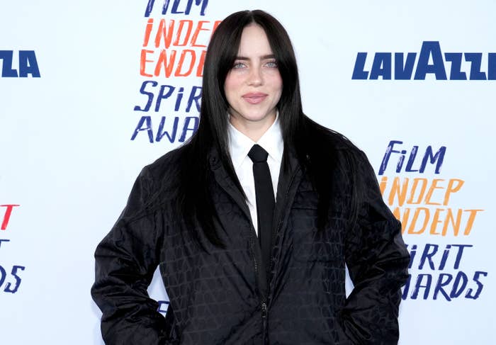 Billie Eilish in a black patterned jacket and tie at an award event
