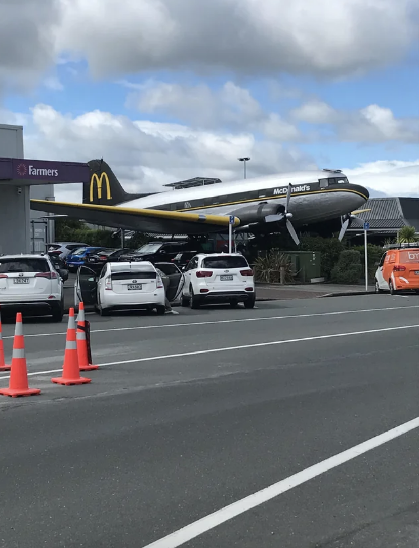 Airplane-shaped McDonald&#x27;s restaurant above parked cars at a unique dining location