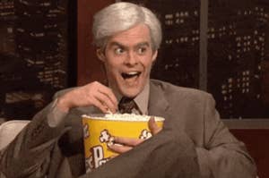 Person with a shocked expression eating popcorn