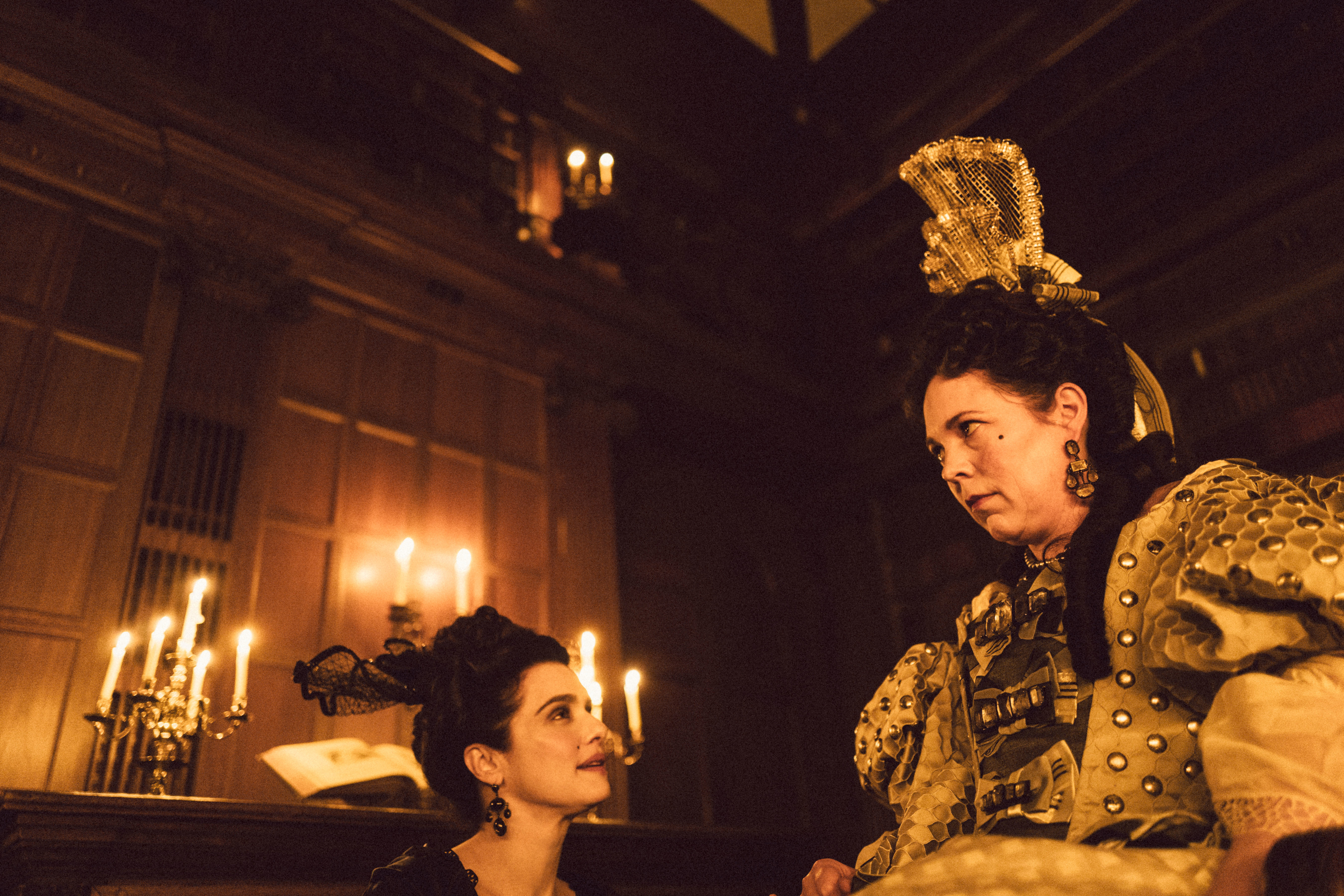 Rachel Weisz and Olivia Colman in elaborate period costumes by candlelight