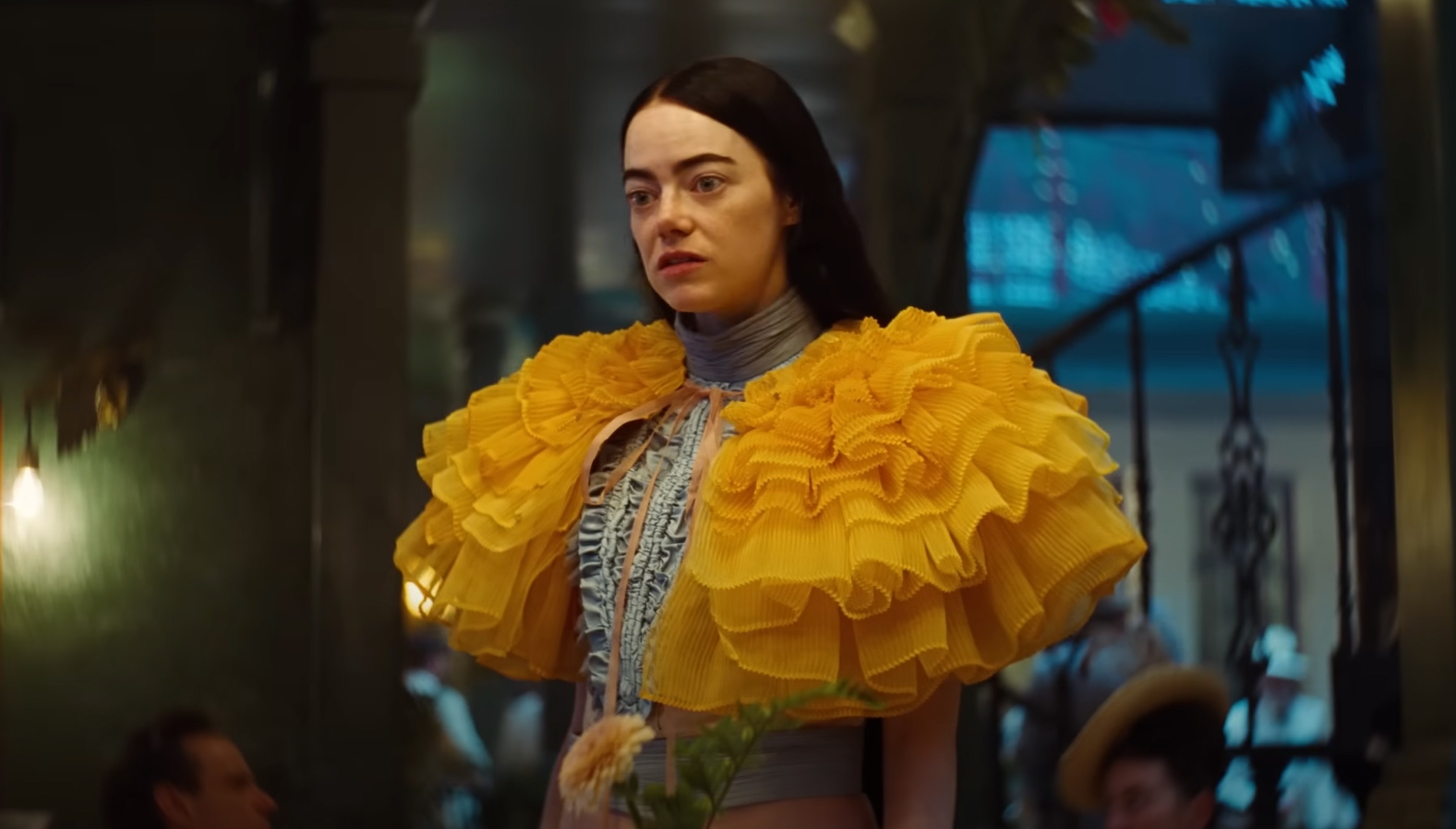 Emma Stone in an elaborate yellow ruffled outfit