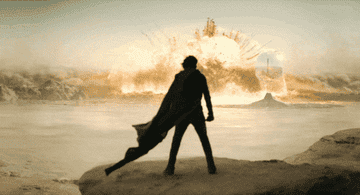 Silhouetted figure standing before an explosive backdrop with dramatic elements