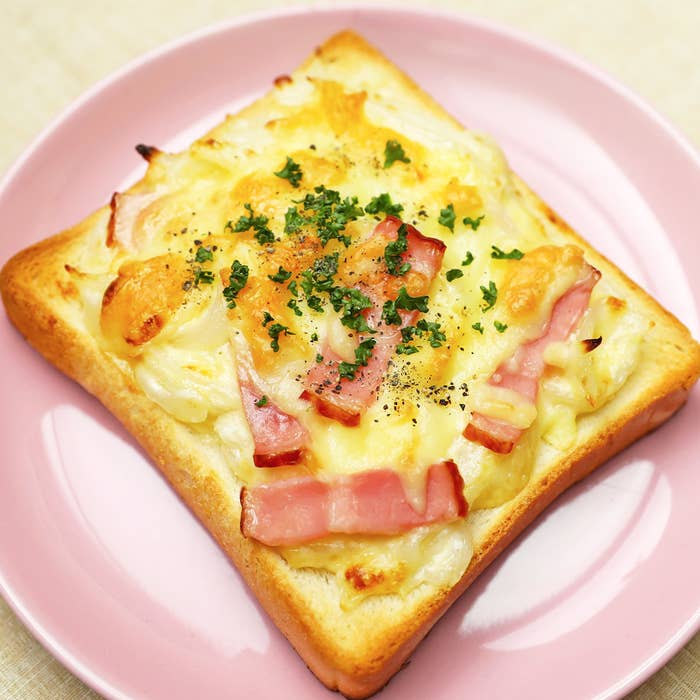 ベーコンとチーズが乗ったトーストがピンクの皿にのっています。