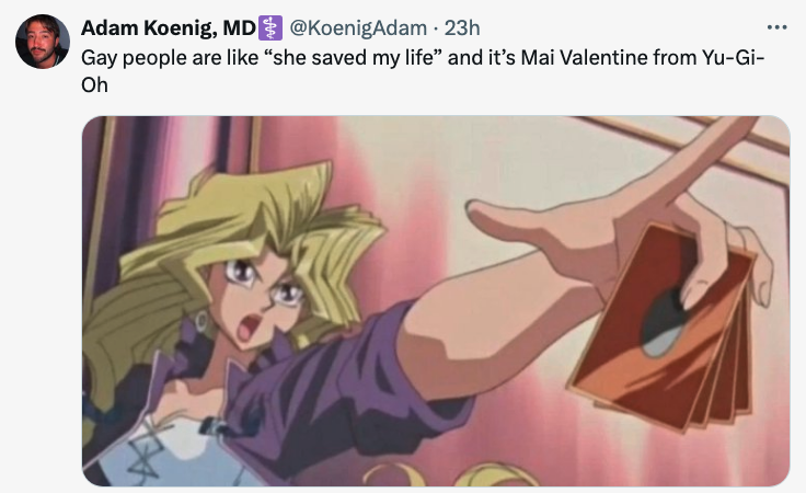 Mai Valentine from Yu-Gi-Oh is depicted with her hand on her chest in a surprised posture, with a card in hand