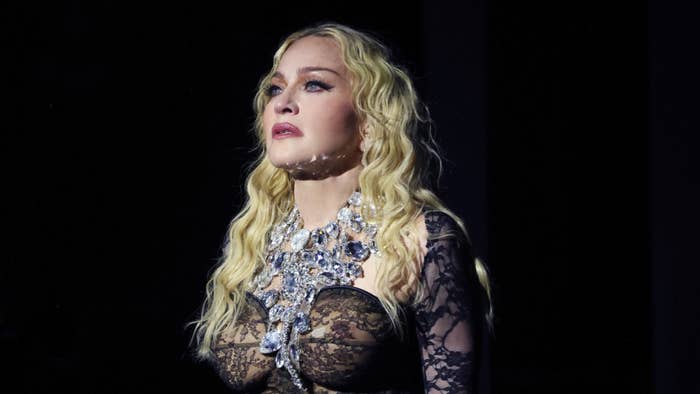 Madonna performing on stage wearing a sparkling necklace and lace details