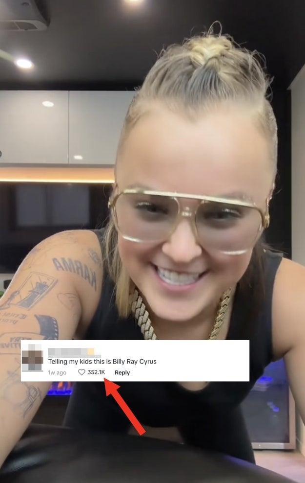 Florence Pugh smiling at the camera with tattoos visible, wearing glasses, beside a humorous comment comparing her to Billy Ray Cyrus