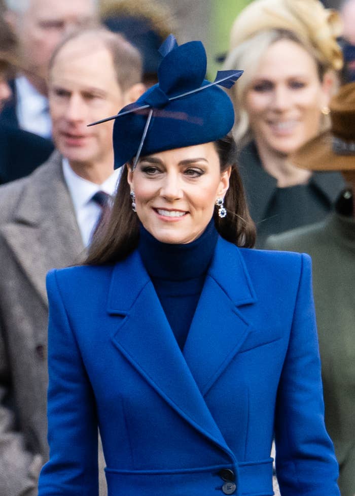 The Princess of Wales in a stylish blue hat and coat, adorned with earrings, at an outdoor event