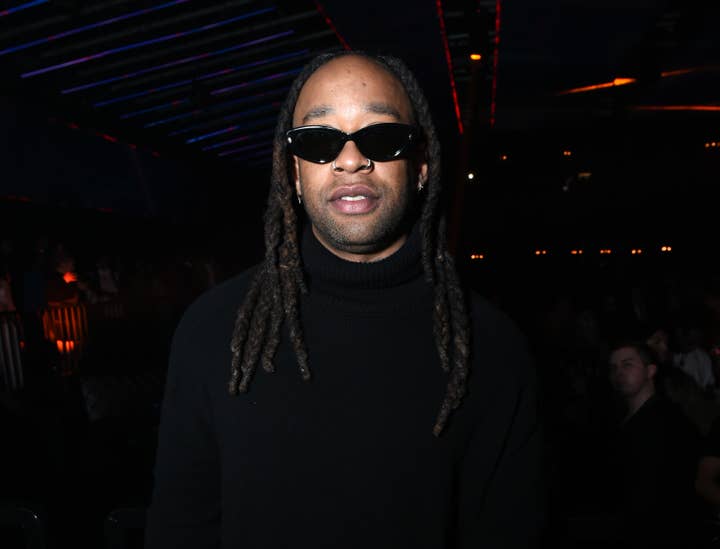 Ty Dolla Sign with braided hair and sunglasses at an event, wearing a black turtleneck