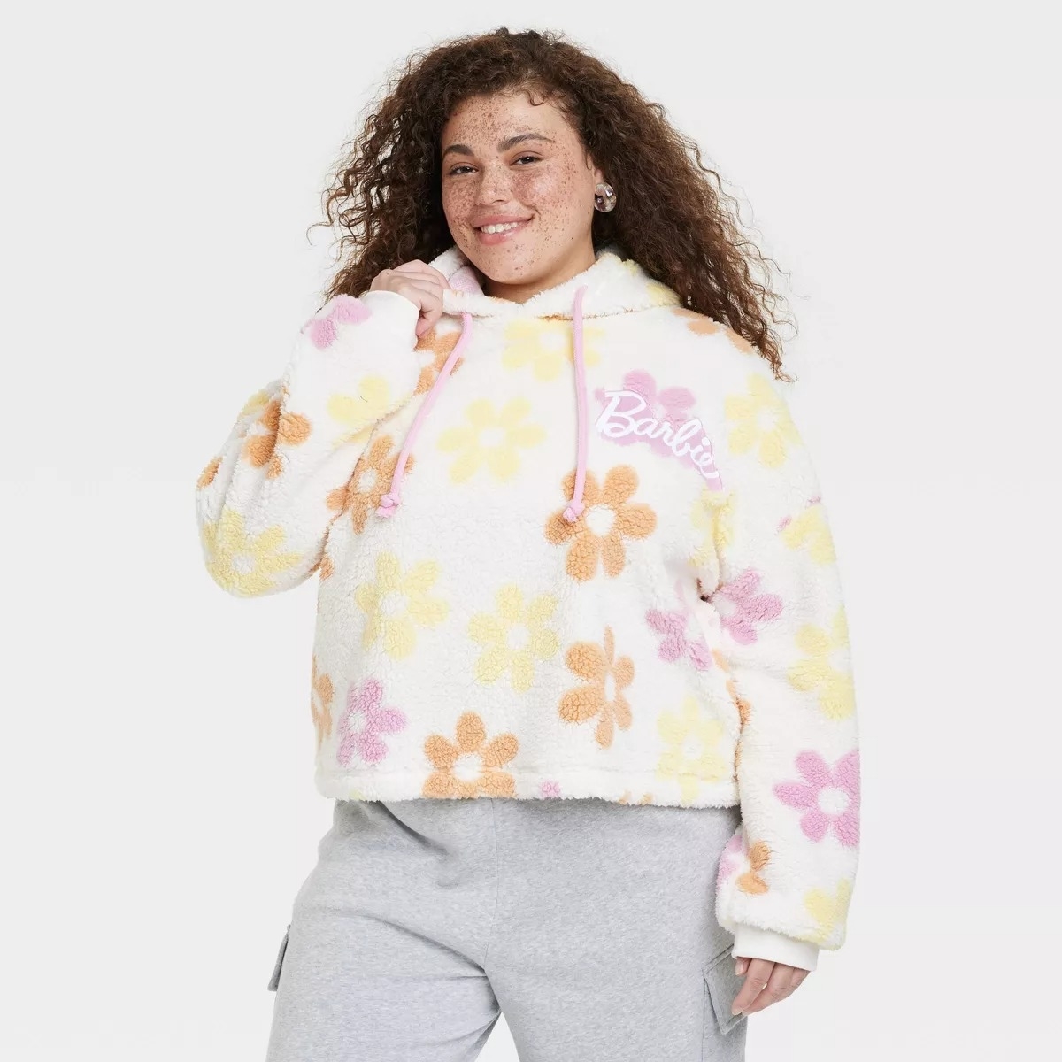 A model in a Barbie floral hoodie with yellow, orange and pink flowers
