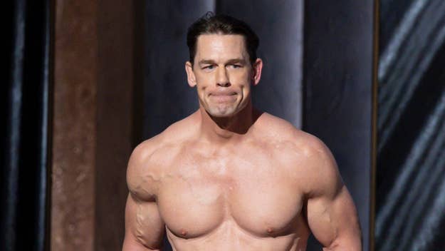 John Cena posing shirtless on stage, showcasing muscular physique