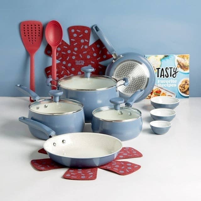 Set of blue cookware with kitchen utensils and a cookbook titled &quot;TASTY Favorite Recipes&quot; on a counter