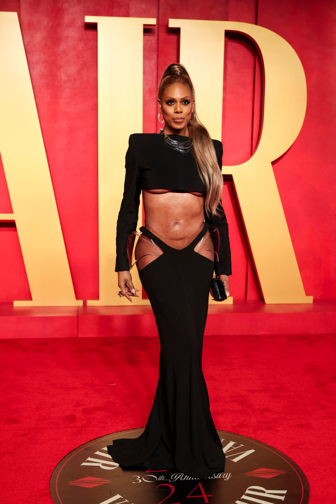 Laverne in a black long-sleeved midriff- and hip-baring cutout gown