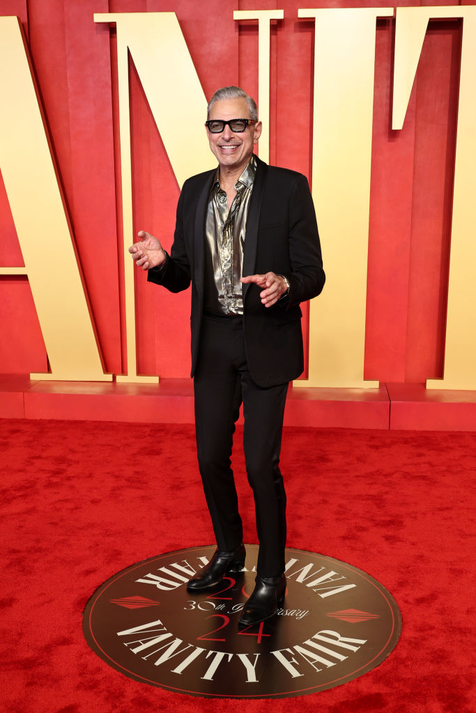 Jeff in a black suit and patterned shirt, posing with a smile on the Vanity Fair Oscar Party red carpet