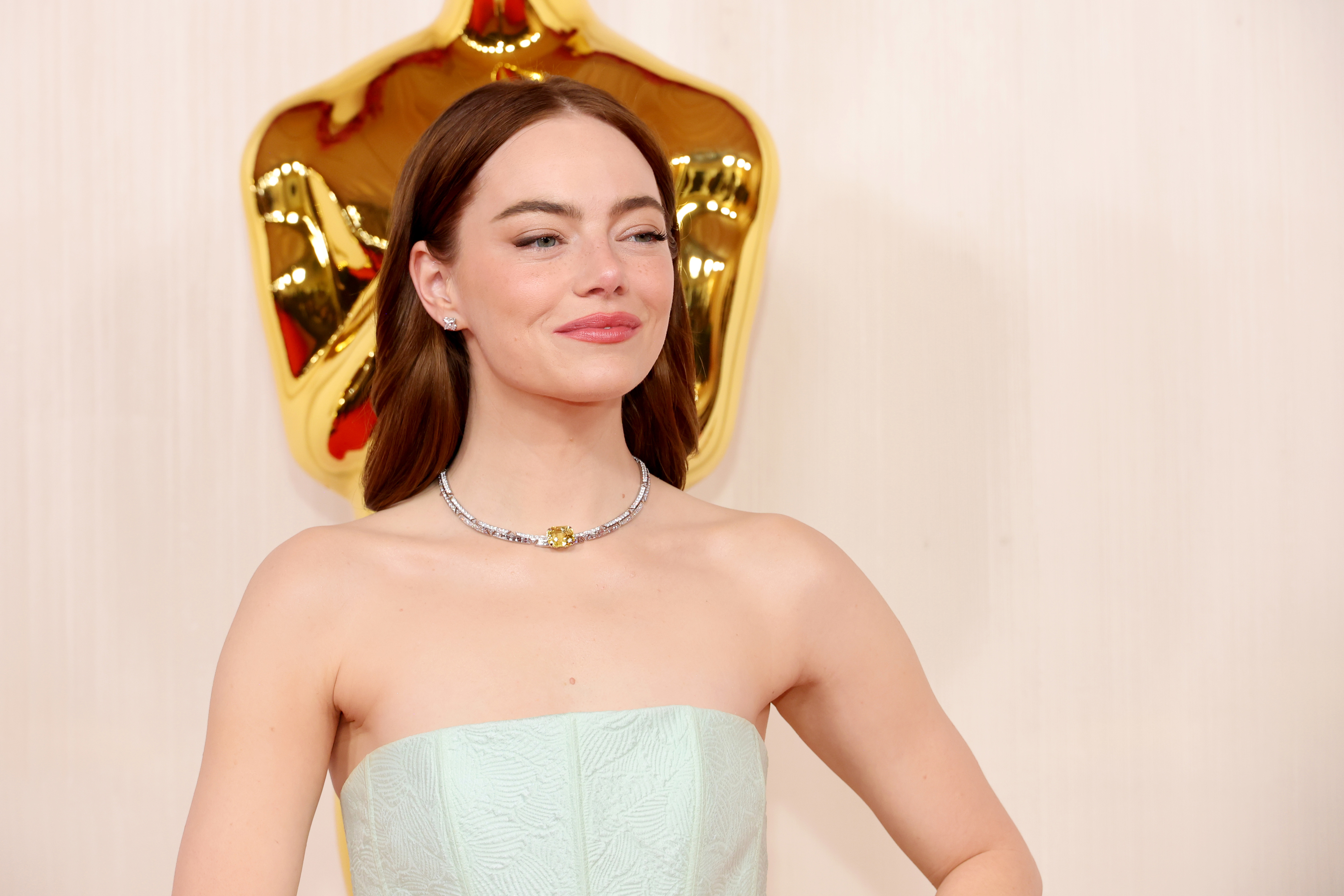 Emma Stone wearing a strapless dress with a statement necklace