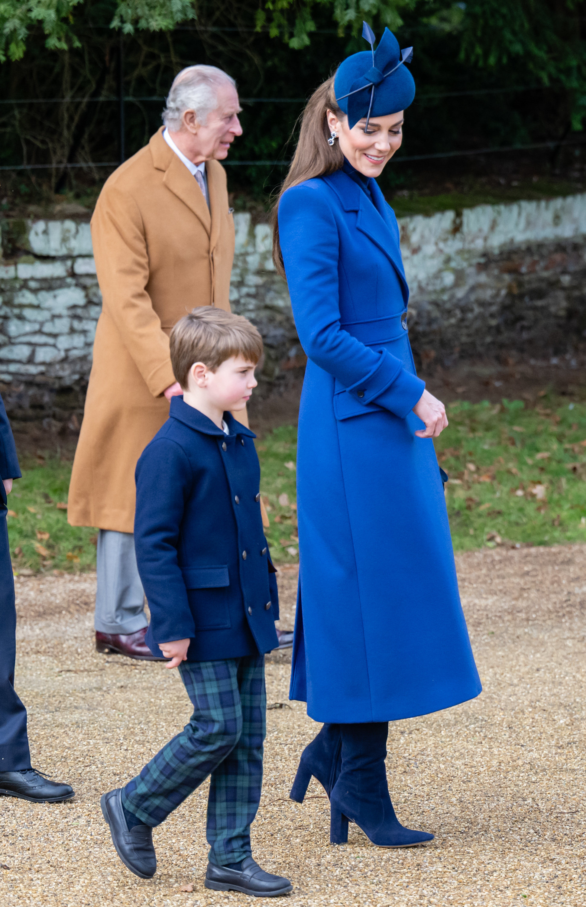 Kate Middleton in a long coat and fascinator, with King Charles III and Prince George at a formal event