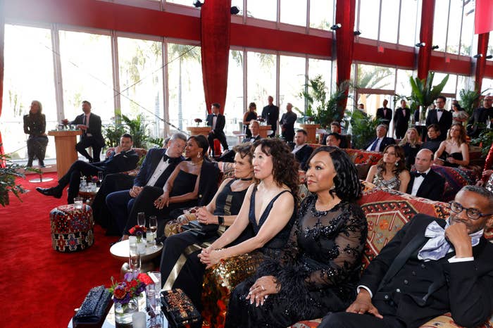 Guests seated at a formal event wearing elegant attire