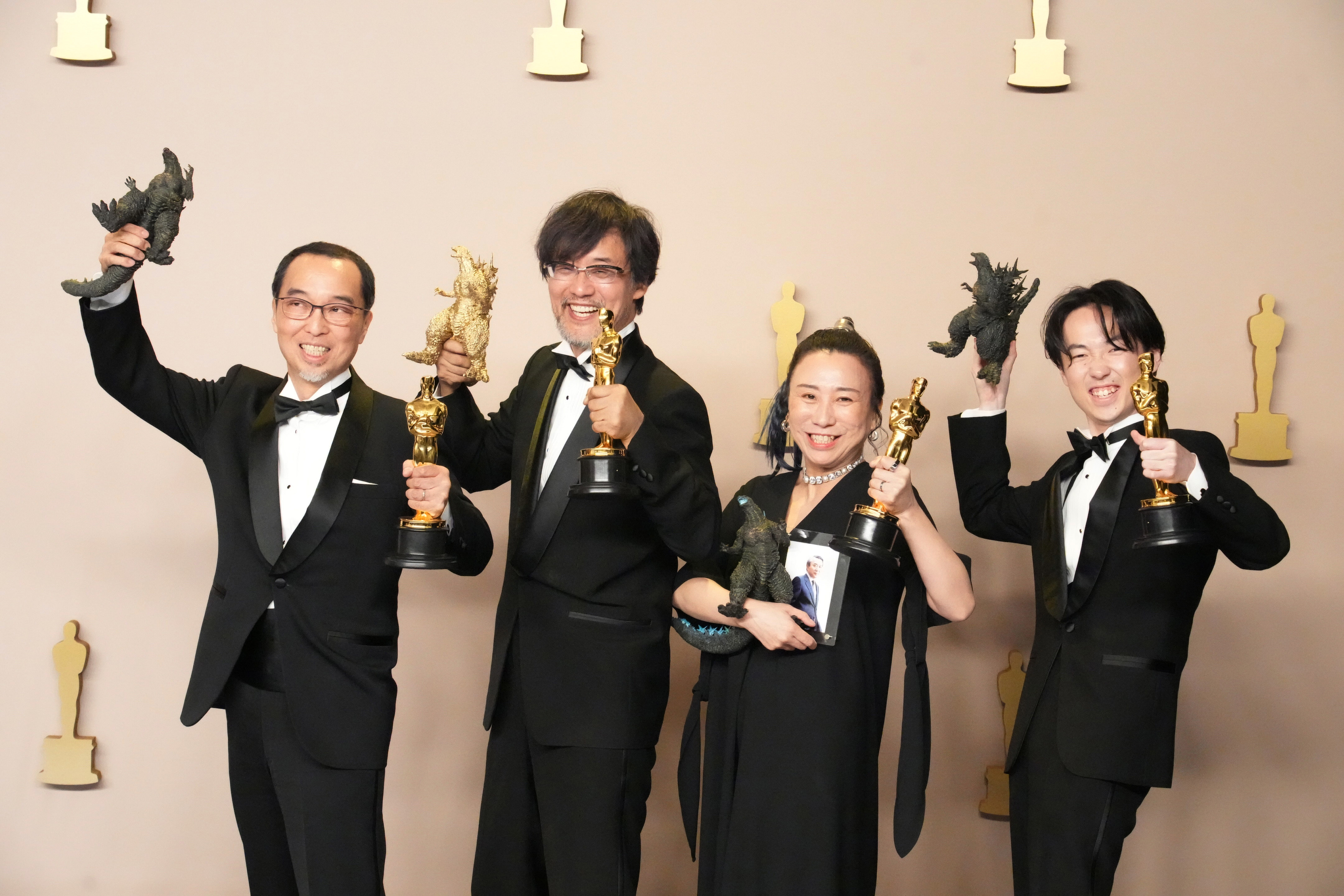 Masaki Takahashi, Takashi Yamazaki, Kiyoko Shibuya, and Tatsuji Nojima smile and pose with Oscars and Godzilla toys