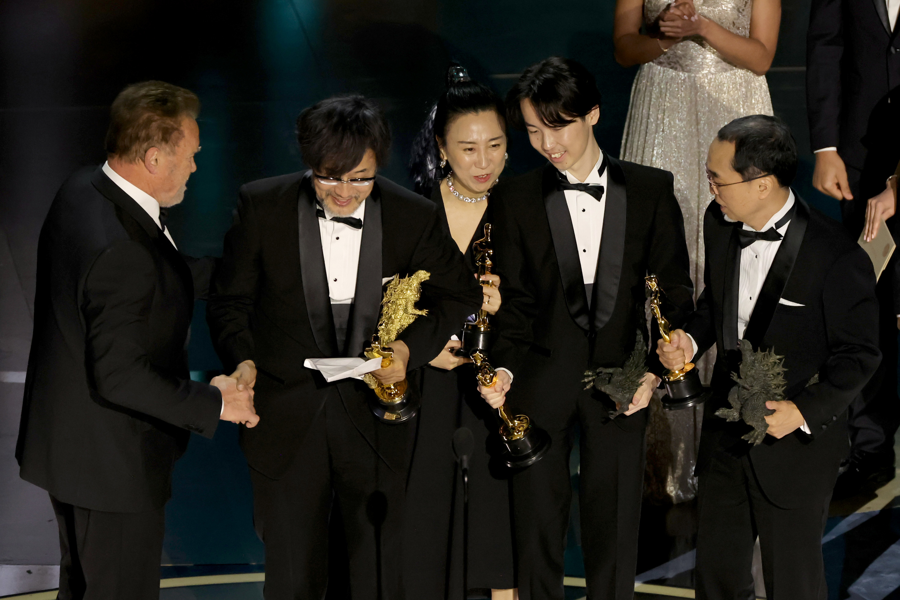 Masaki Takahashi, Takashi Yamazaki, Kiyoko Shibuya, and Tatsuji Nojima accept the Best Visual Effects Oscar from Arnold Schwarzenegger