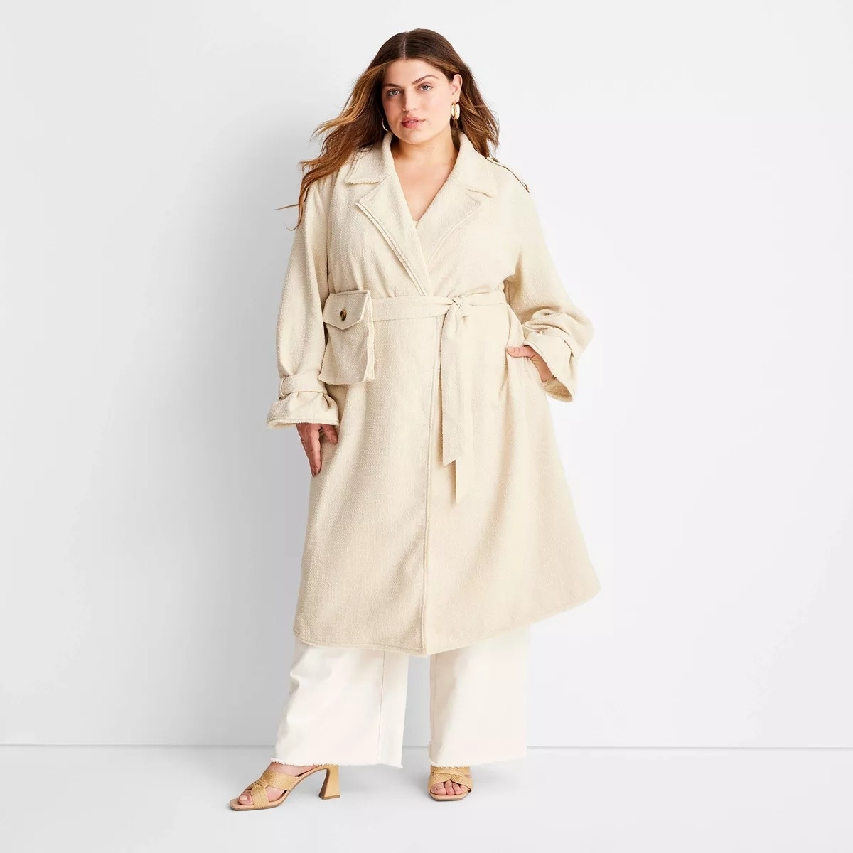 A model poses in a beige trench coat
