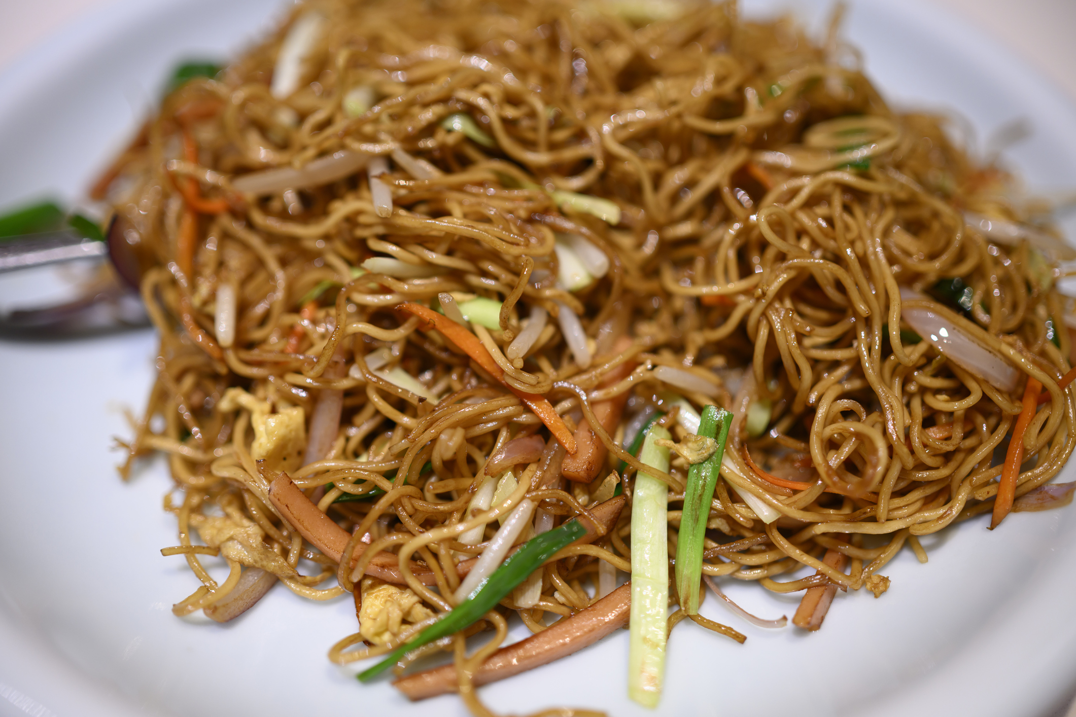 Plate of stir-fried noodles with vegetables and egg
