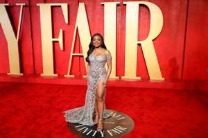 Woman in beaded gown with high-slit poses at Vanity Fair event