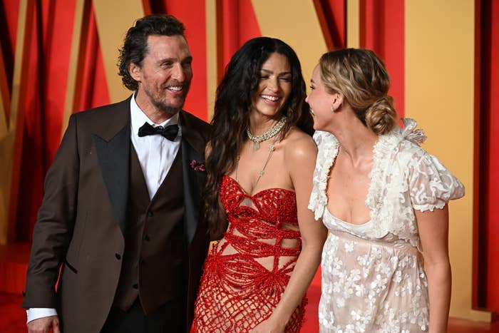 Matthew McConaughey and Camila Alves smiling and talking to another woman