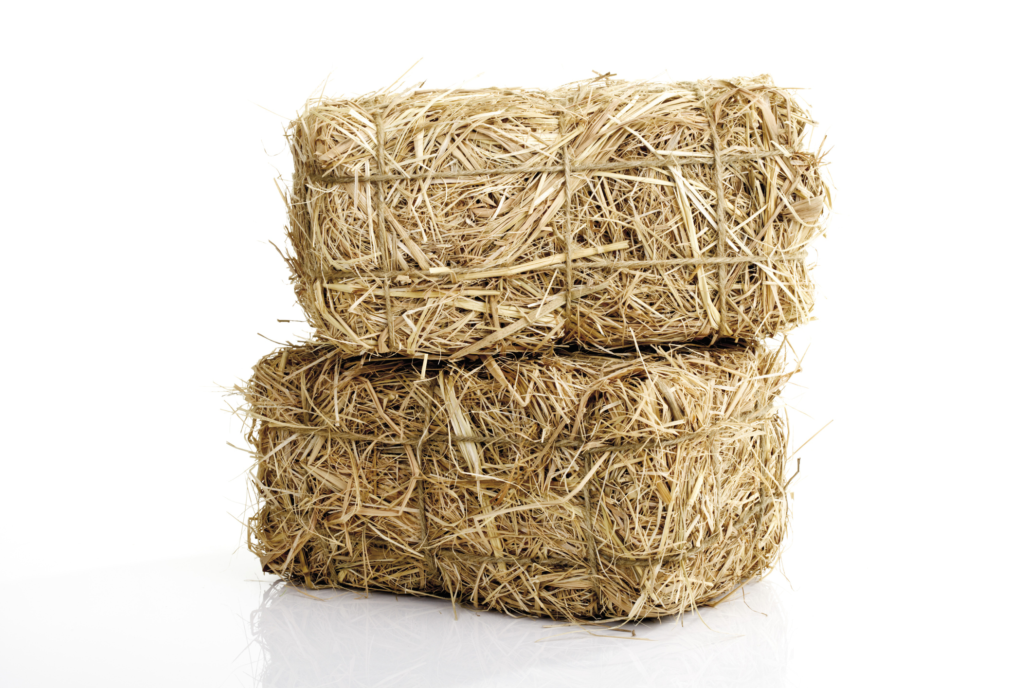 Two stacked bales of hay isolated on a white background
