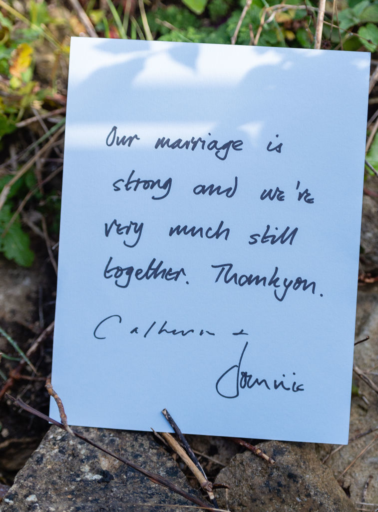 Handwritten note expressing strength of marriage, signed by two individuals, resting on natural ground