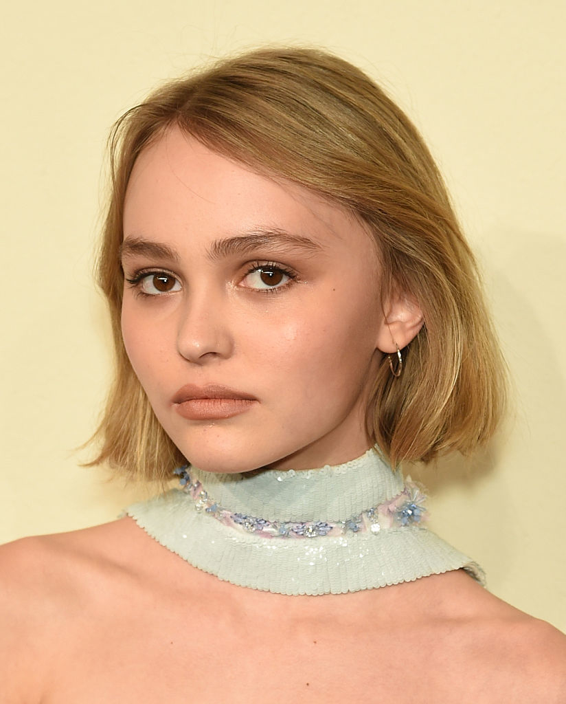 Close-up of Lily-Rose Depp with a sheer ruffled neckline and a simple earring