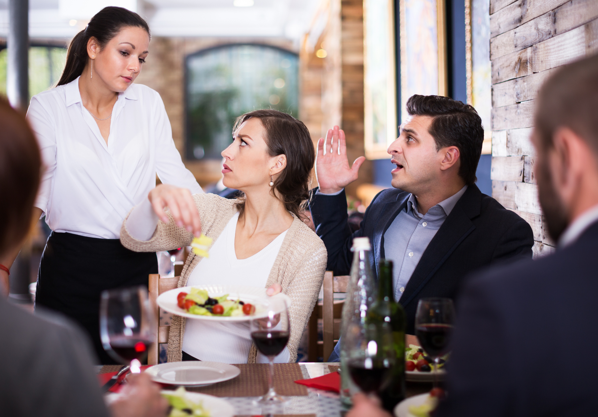 A waiter engaging with a table of rude customers